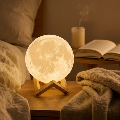 3D moon lamp glowing warm white on a nightstand in a cozy hygge bedroom with soft ambient lighting